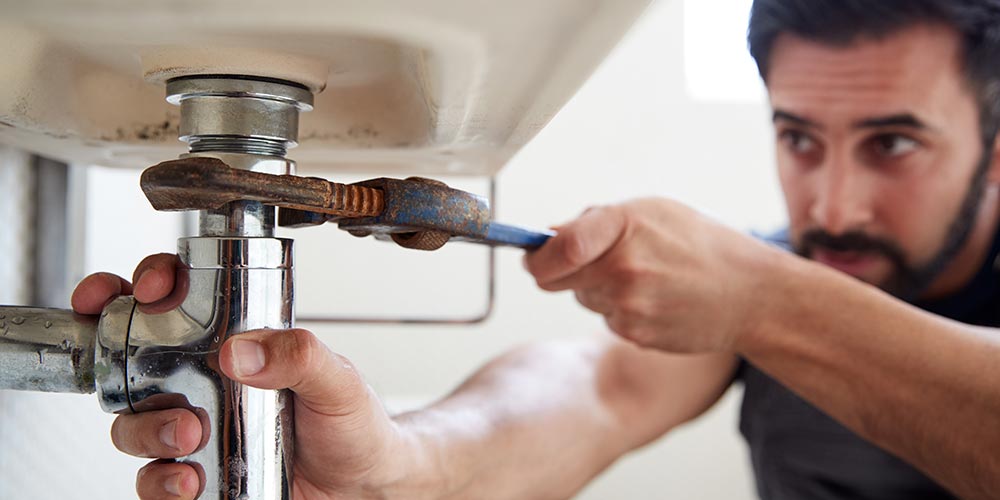 Plumber fixing fixtures with wrench